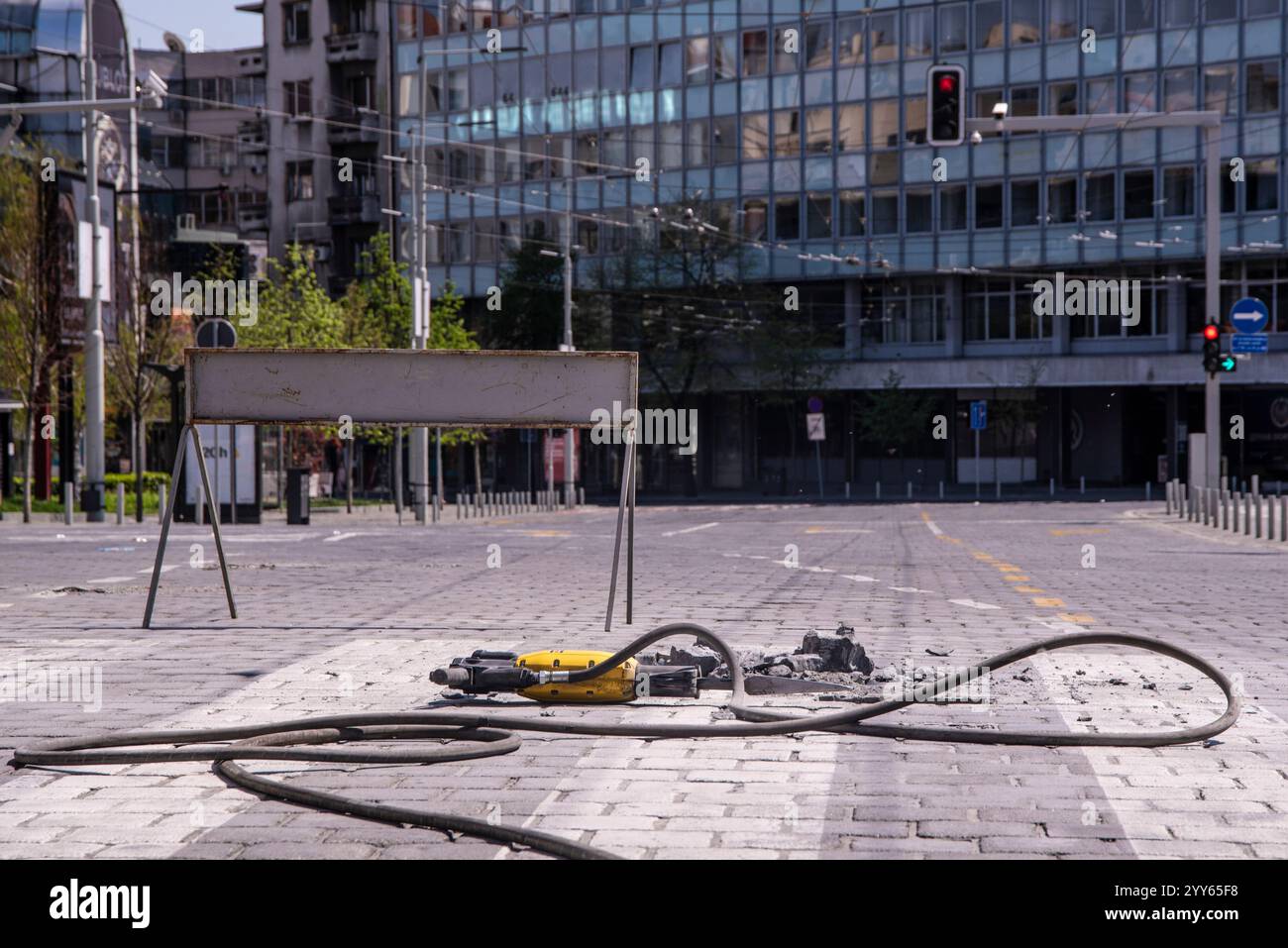 A stone was removed from a pedestrian crossing with electric rotary hammer drill. Close-up. Construction zone or roadworks on city street. Stock Photo