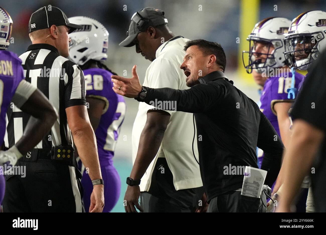 James Madison head coach Bob Chesney, right, talks with an official ...