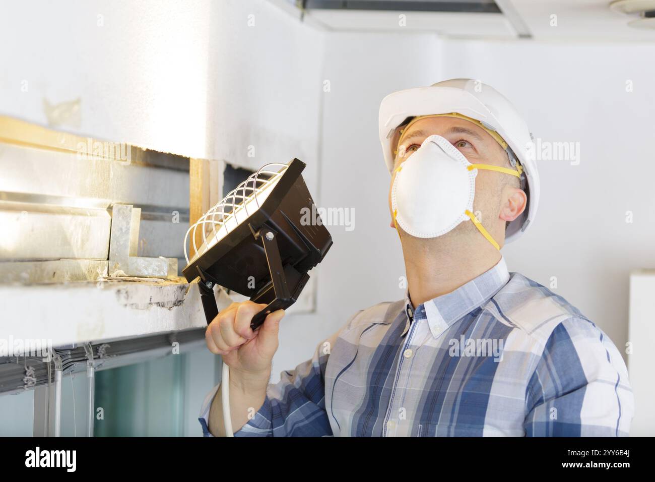 man checking the state of the ceiling Stock Photo