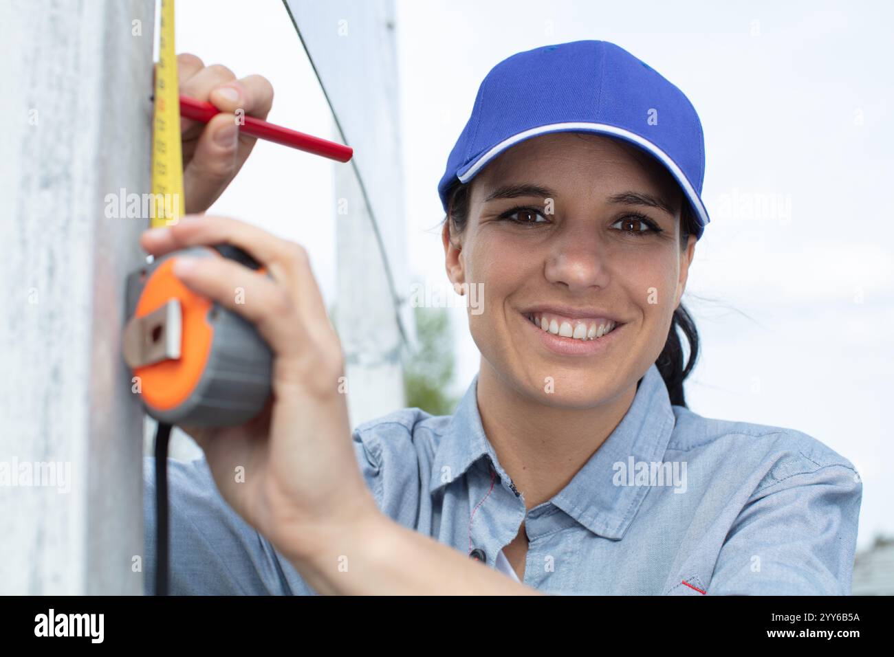 woman holding a meter measuring dimensions on wall Stock Photo - Alamy