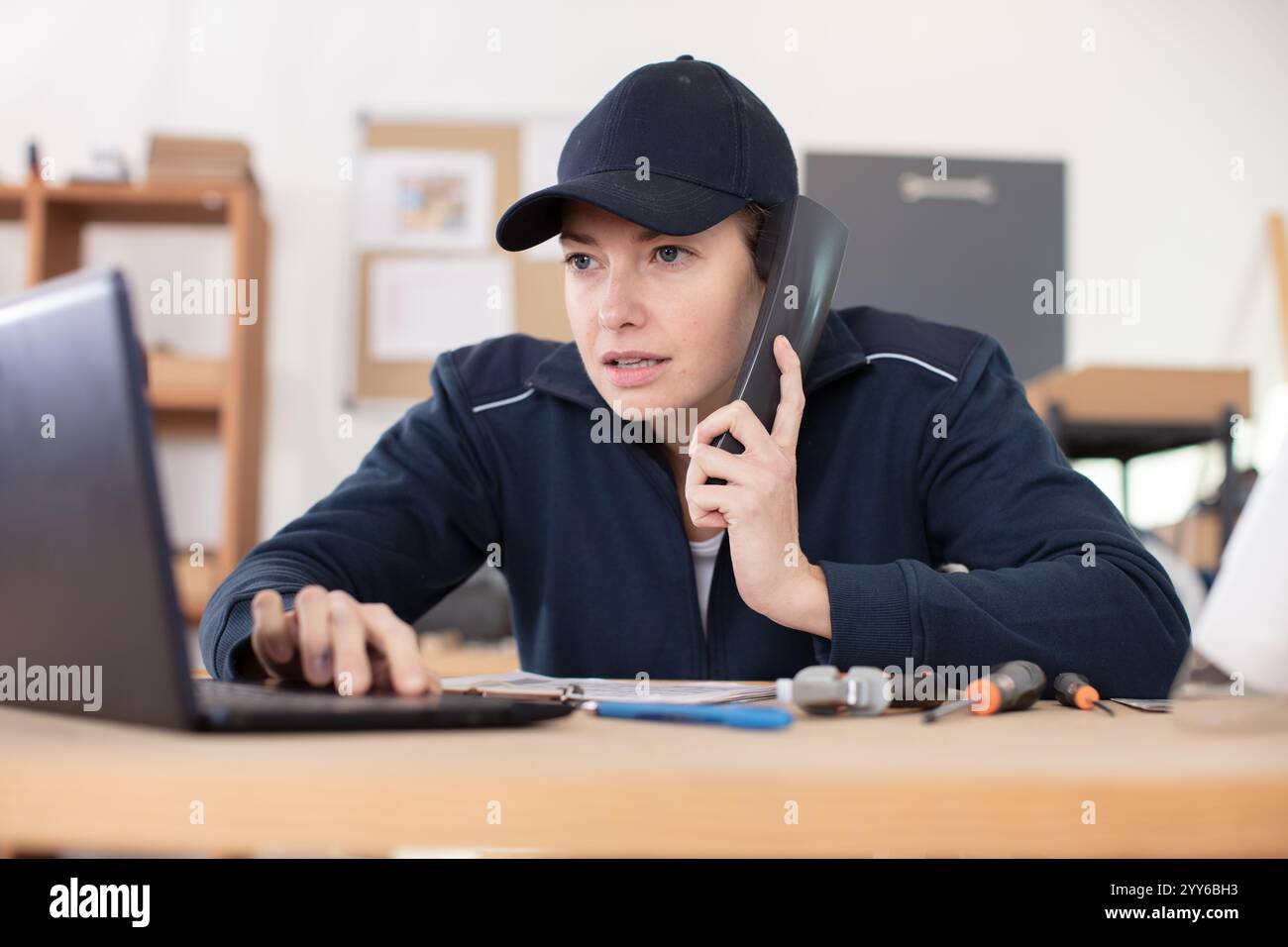 female on the phone fixing a computer Stock Photo