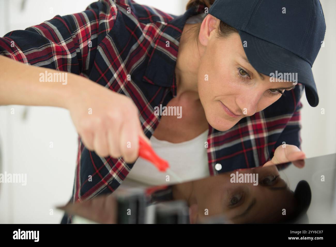 woman installing induction hobs in a kitchen Stock Photo