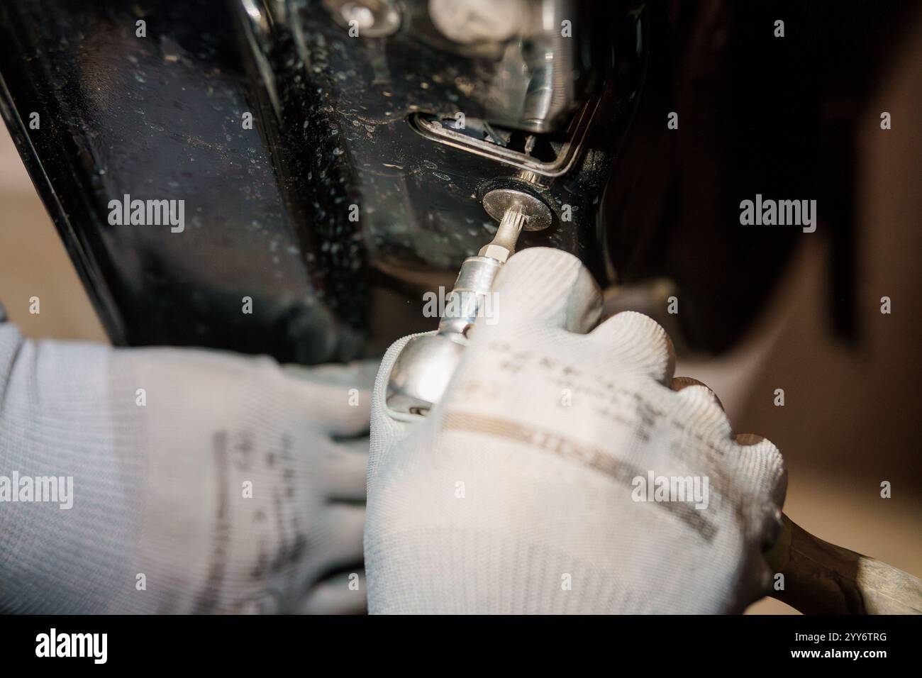 Precision Engineering: A Close-Up of Hand Using a Screwdriver in a Mechanical Setting. Stock Photo