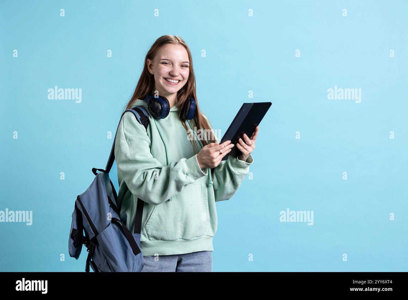 Overjoyed teenager using tablet, laughing at amusing social media posts ...