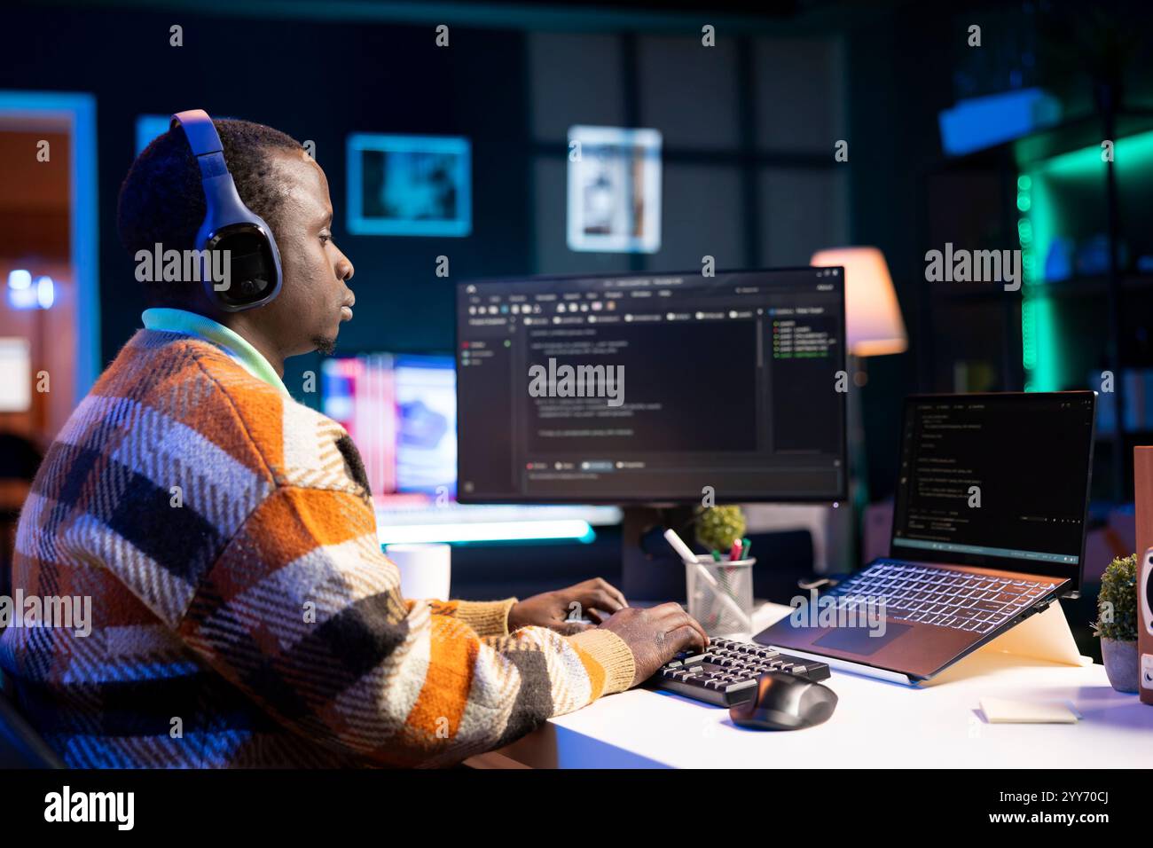 Black software engineer writes complex binary code scripts on computer, cybersecurity. Teleworking IT specialist in home office using programming language to safeguard consumer data. Stock Photo