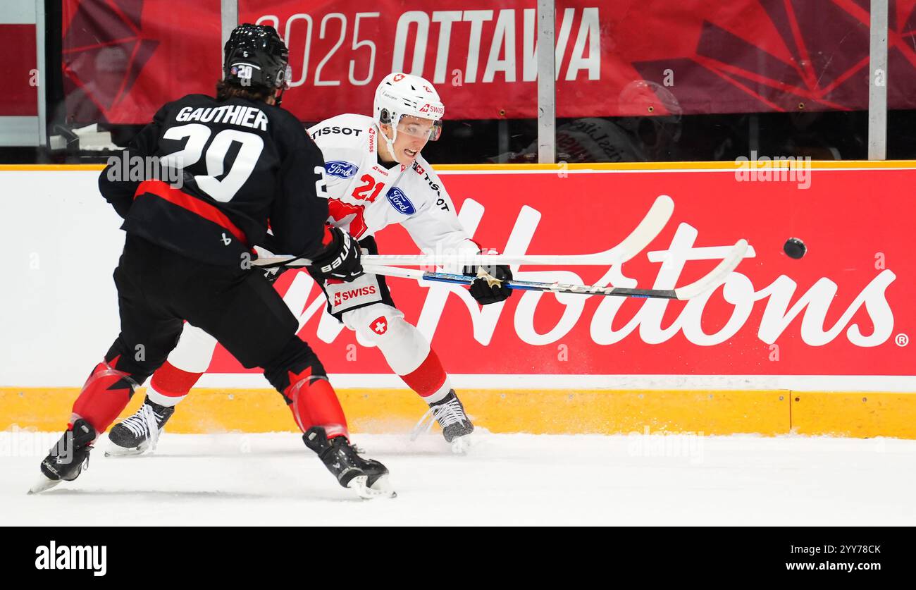 Switzerland's Ludvig Johnson (21) moves the puck as Canada's Ethan
