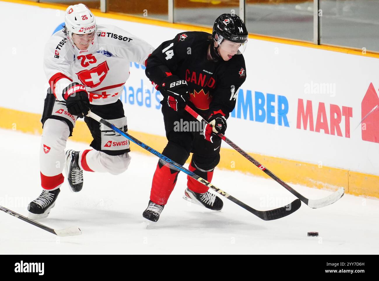 Canada's Berkly Catton (14) protects the puck from Switzerland's Basile