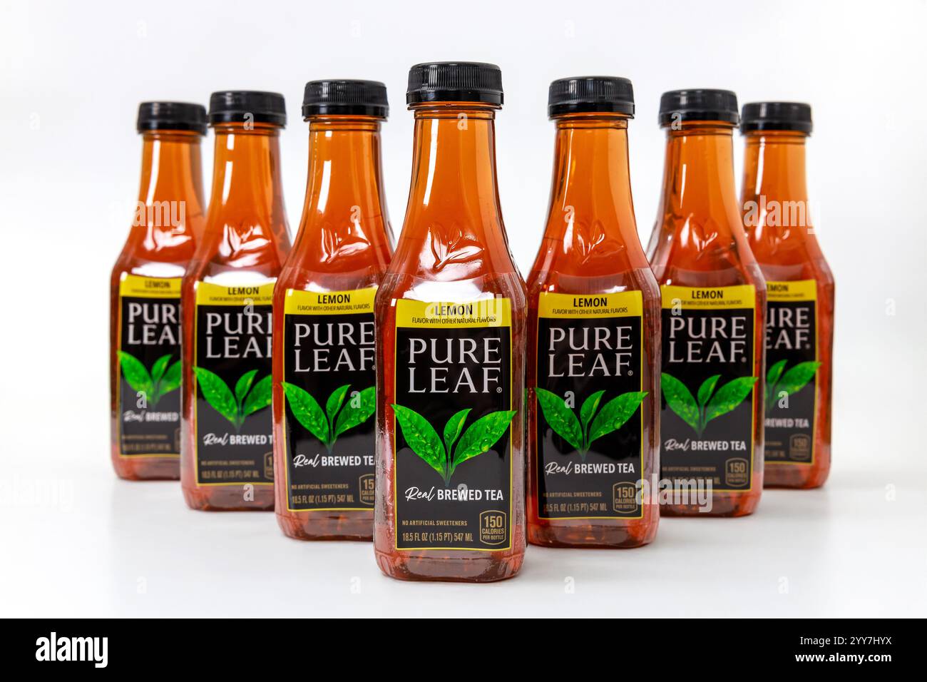 Bottles of brewed tea arranged in row with lemon flavor in well-lit setting Stock Photo