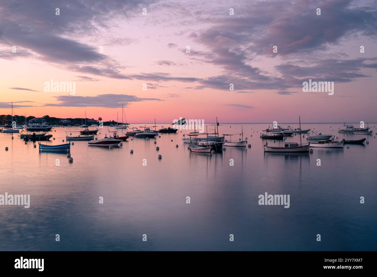 Boats anchored in the bay of Cadaqués in the pastel-coloured dawn ...