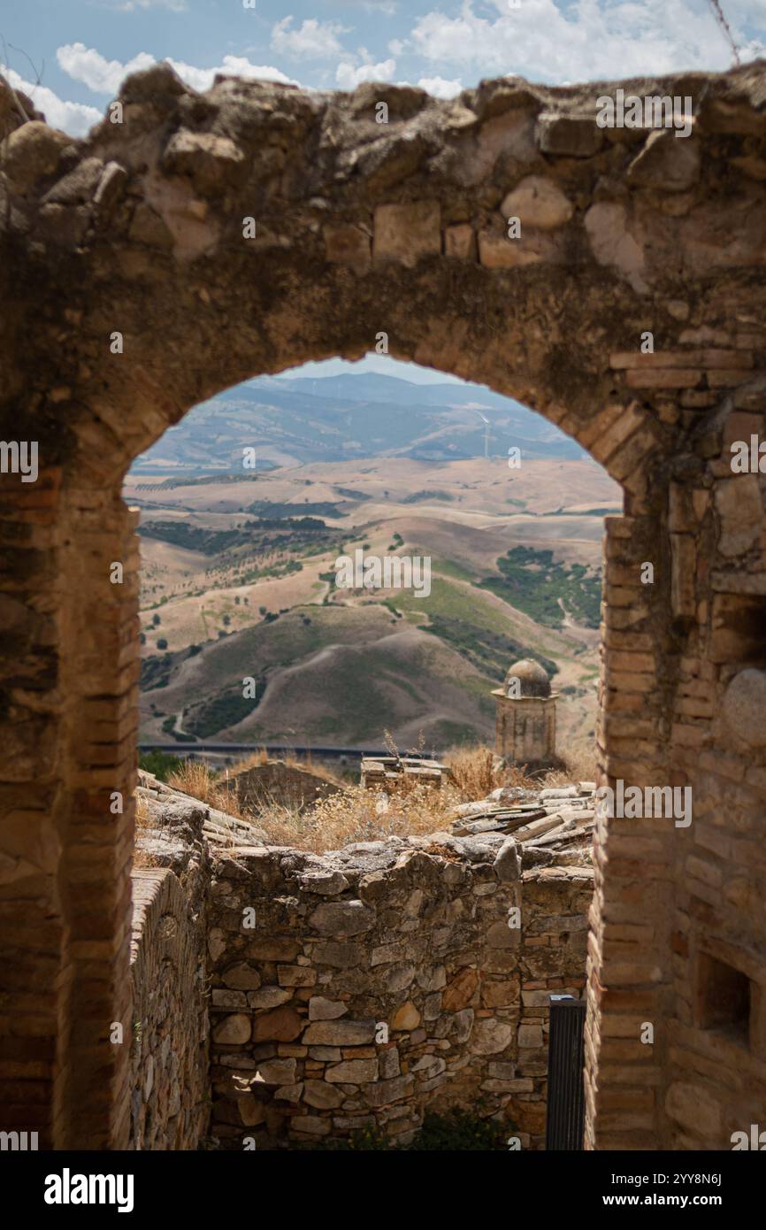 Scenic view through a stone archway framing a serene rural landscape of ...