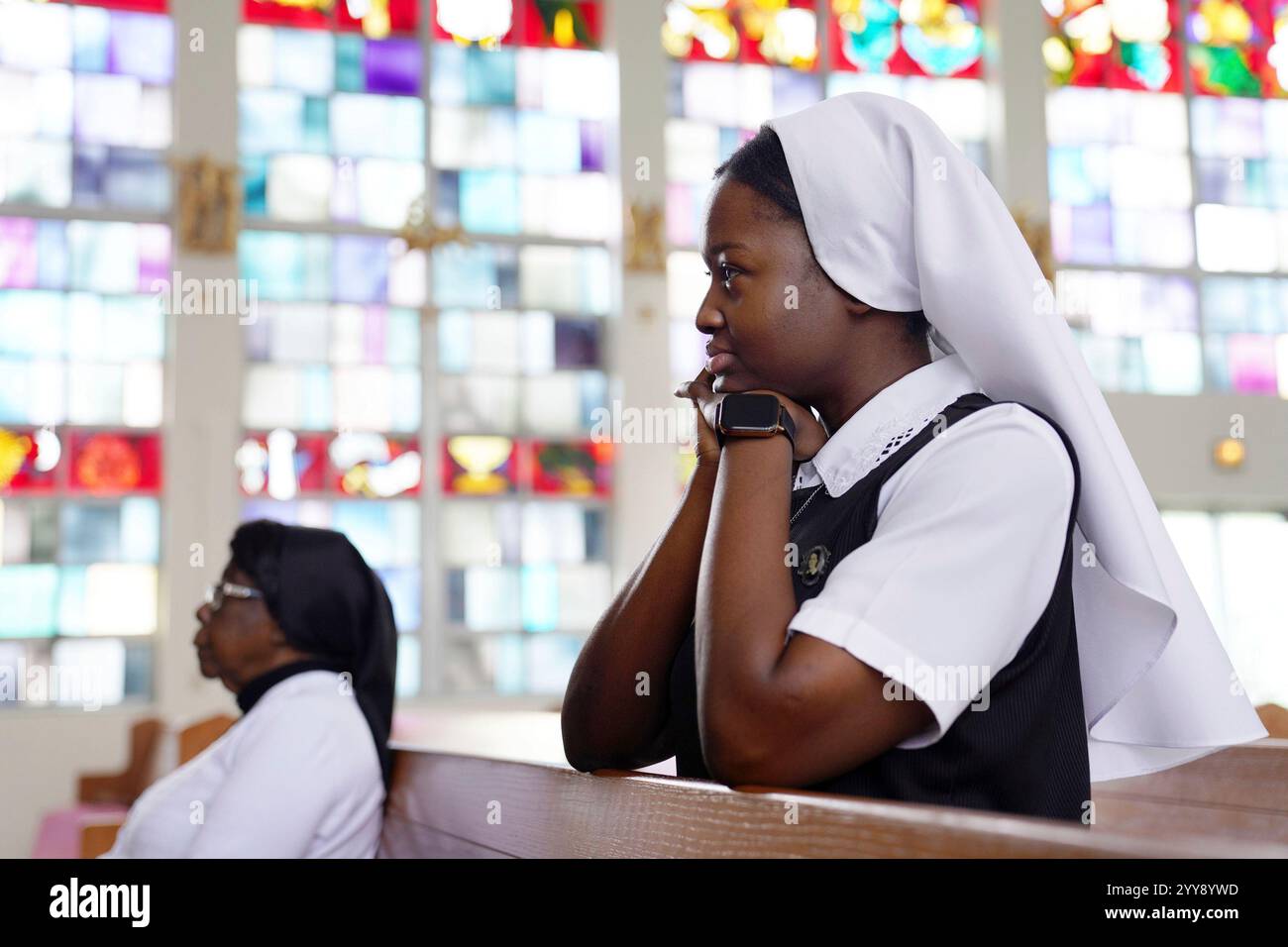 Sister Seyram Mary Adzokpa, right, kneels in prayer in the chapel at