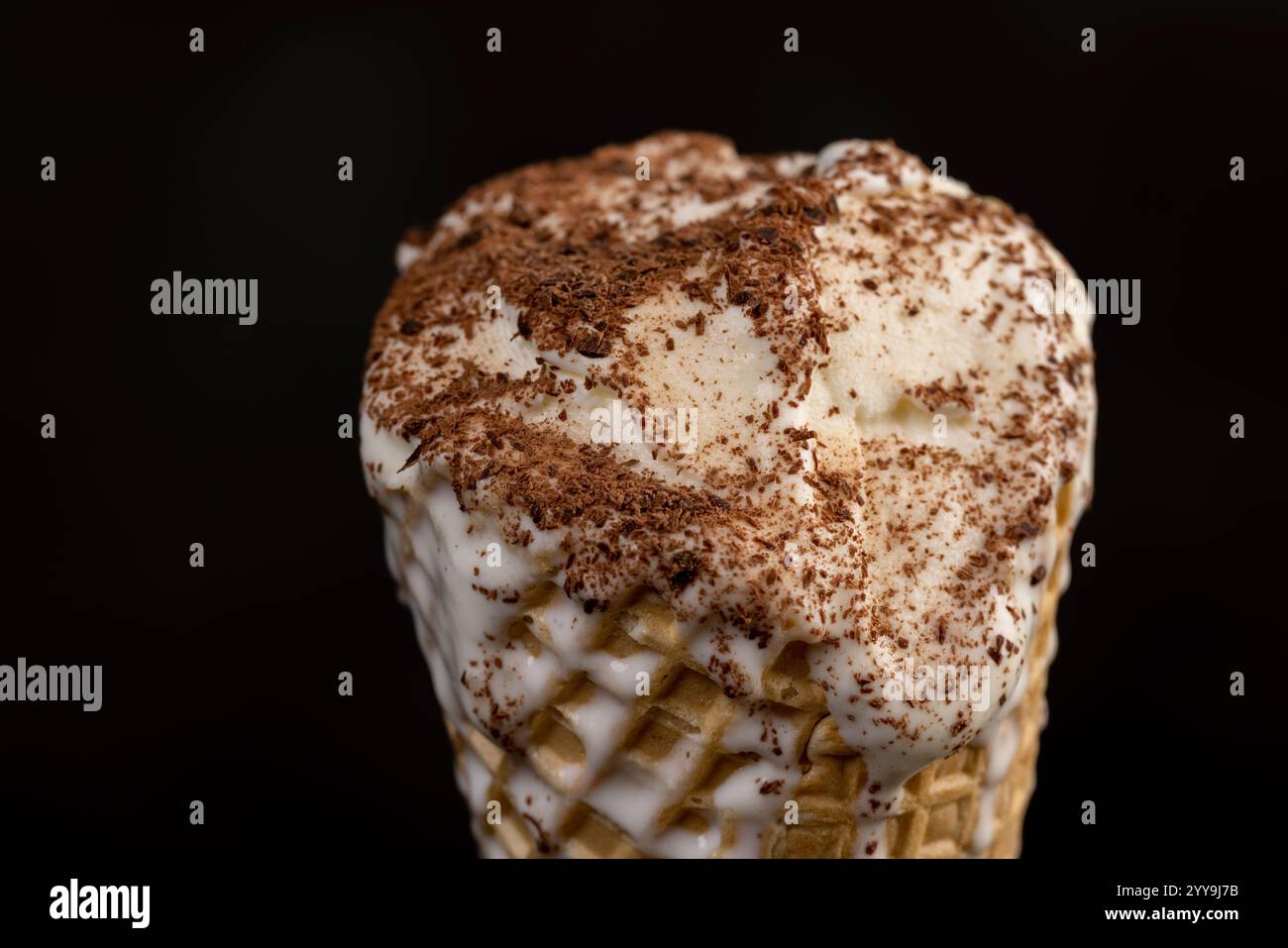 creamy ice cream sprinkled with chocolate in a waffle cone on a black ...