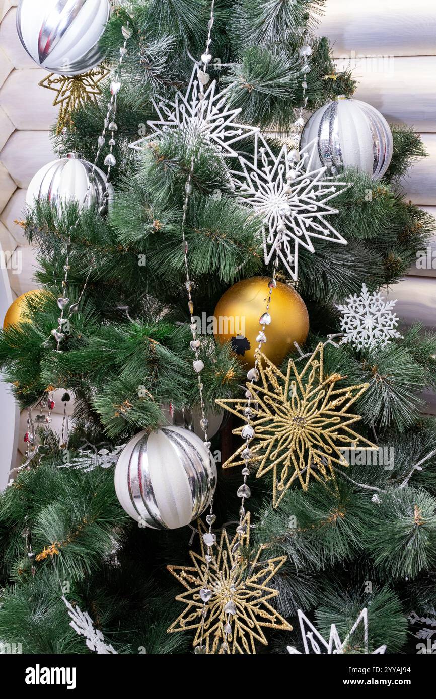 A beautifully decorated Christmas tree filled with silver and gold ...