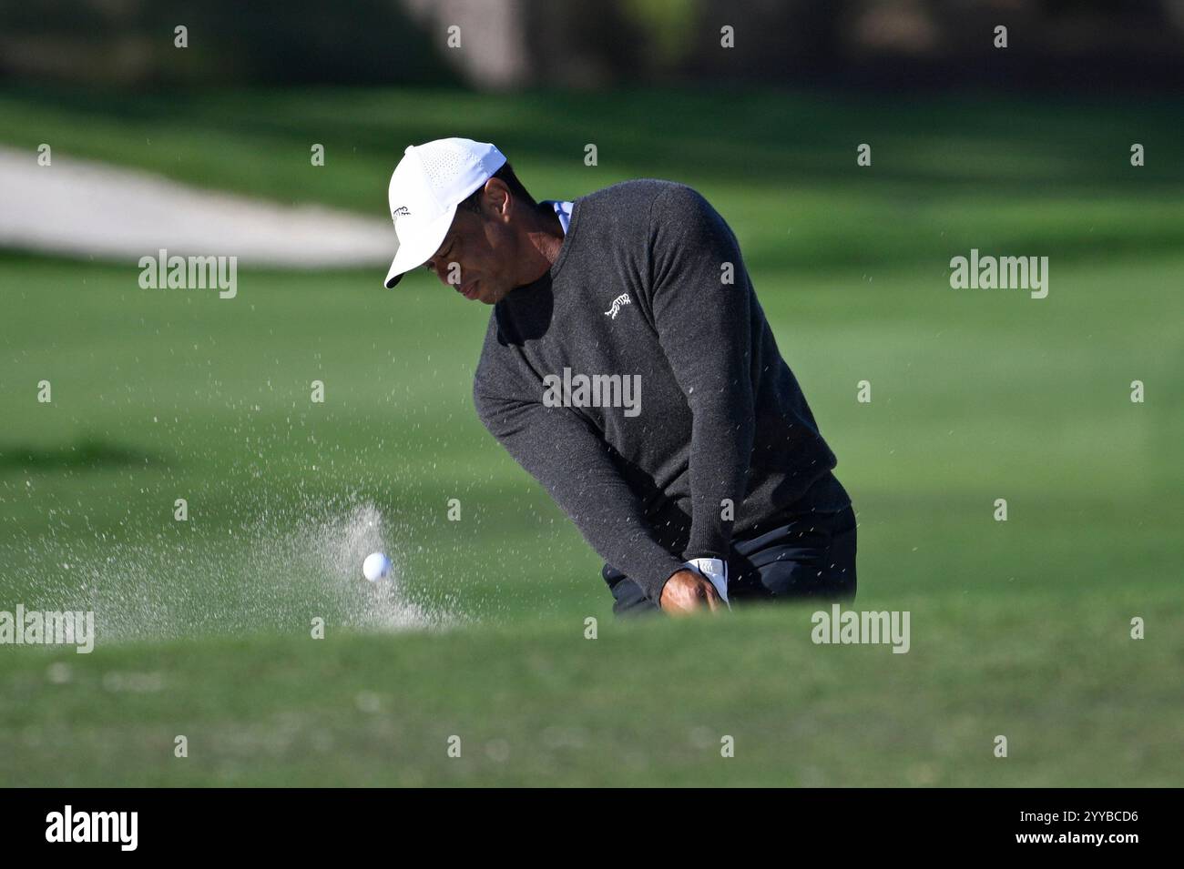 Tiger Woods hits from a bunker onto the 18th green during a proam