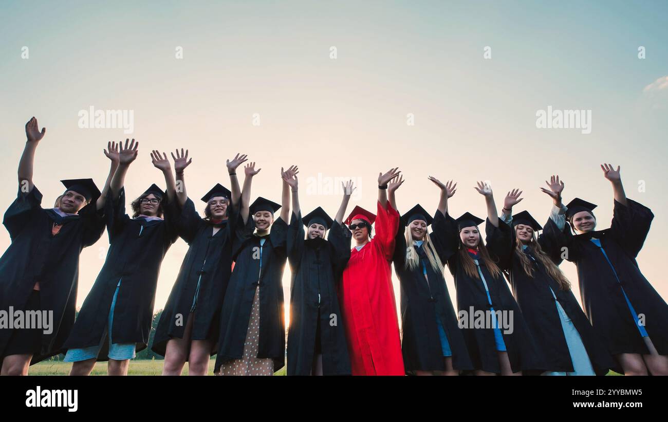 Graduation gown clad students joyfully tossing caps in the air to ...