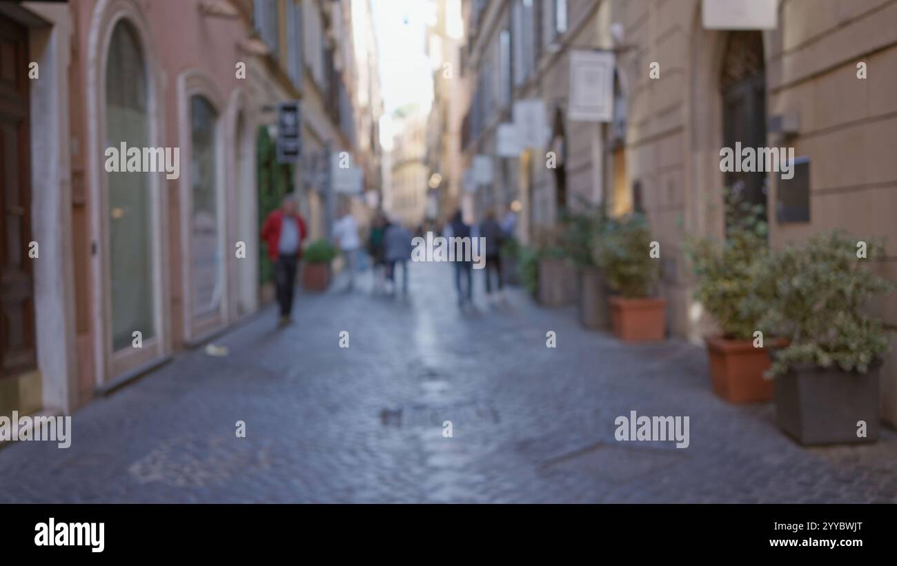 Blurred people walking along cobblestone street in historic rome with ...