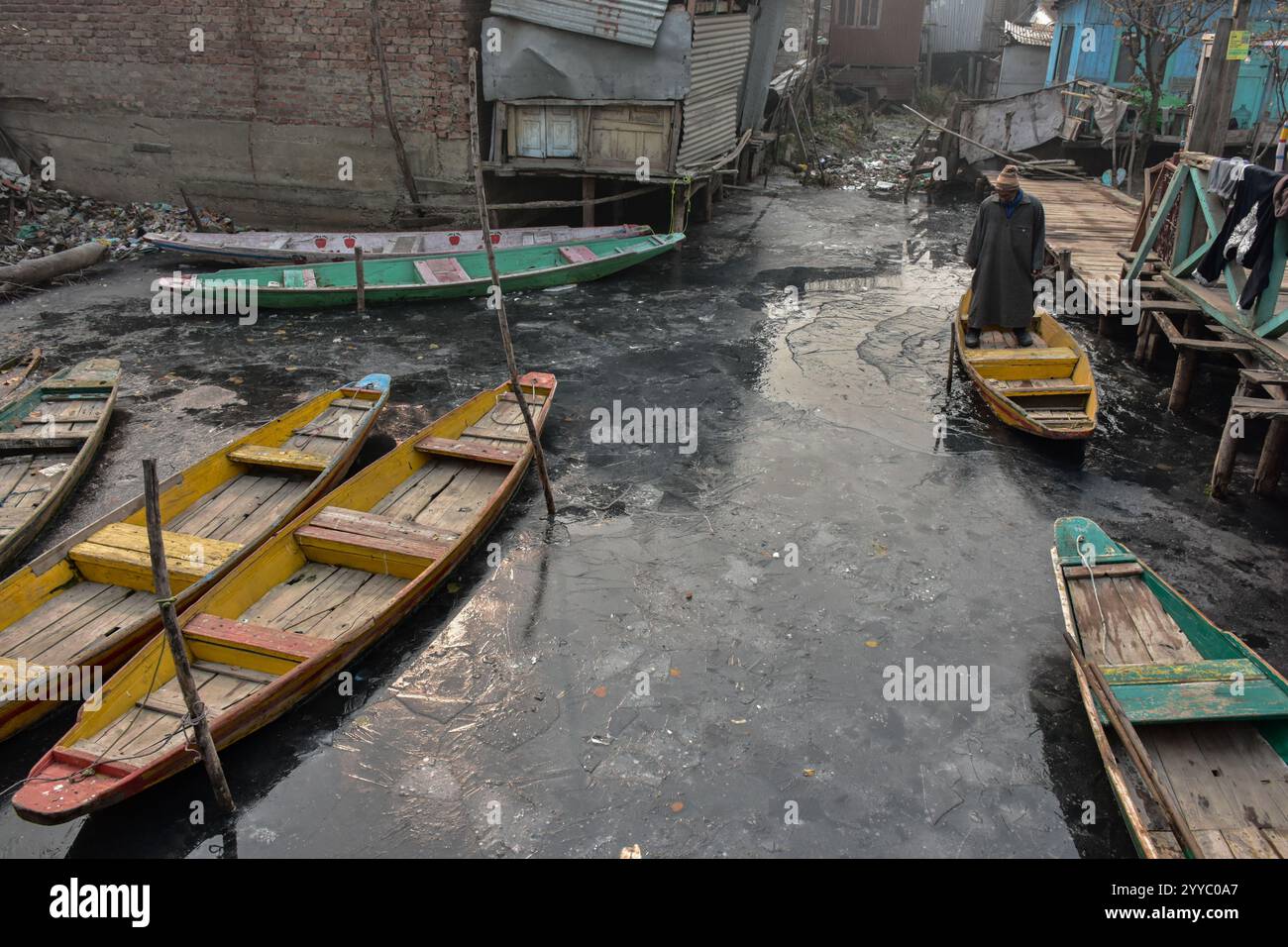 a-boatman-makes-his-way-across-the-partially-frozen-dal-lake-following