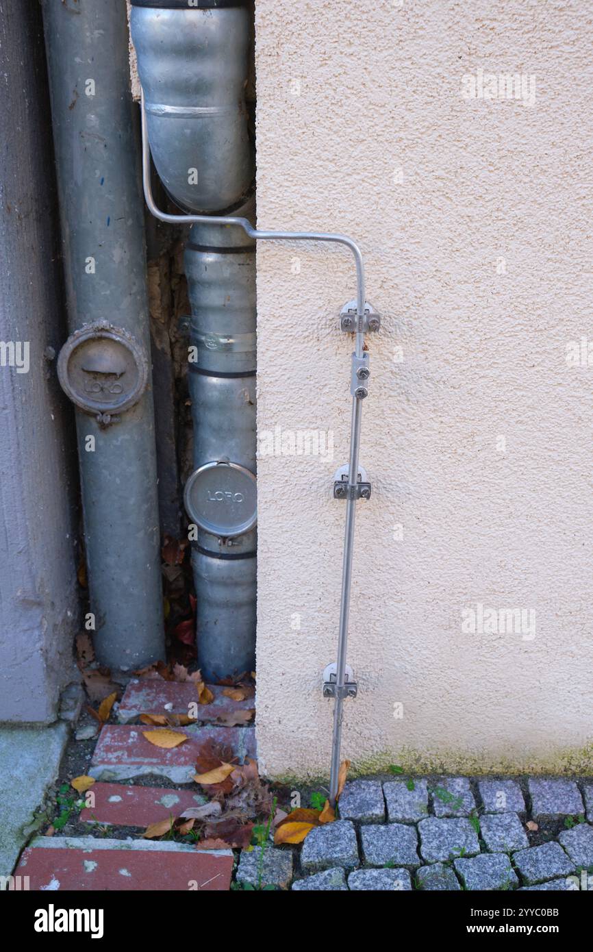 Berlin, Germany, November 27, 2024, Grounding of a lightning rod on a house wall with downpipes Stock Photo