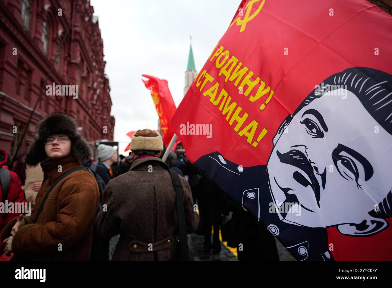 A man holds a flag with a portrait of Soviet leader Joseph Stalin in ...
