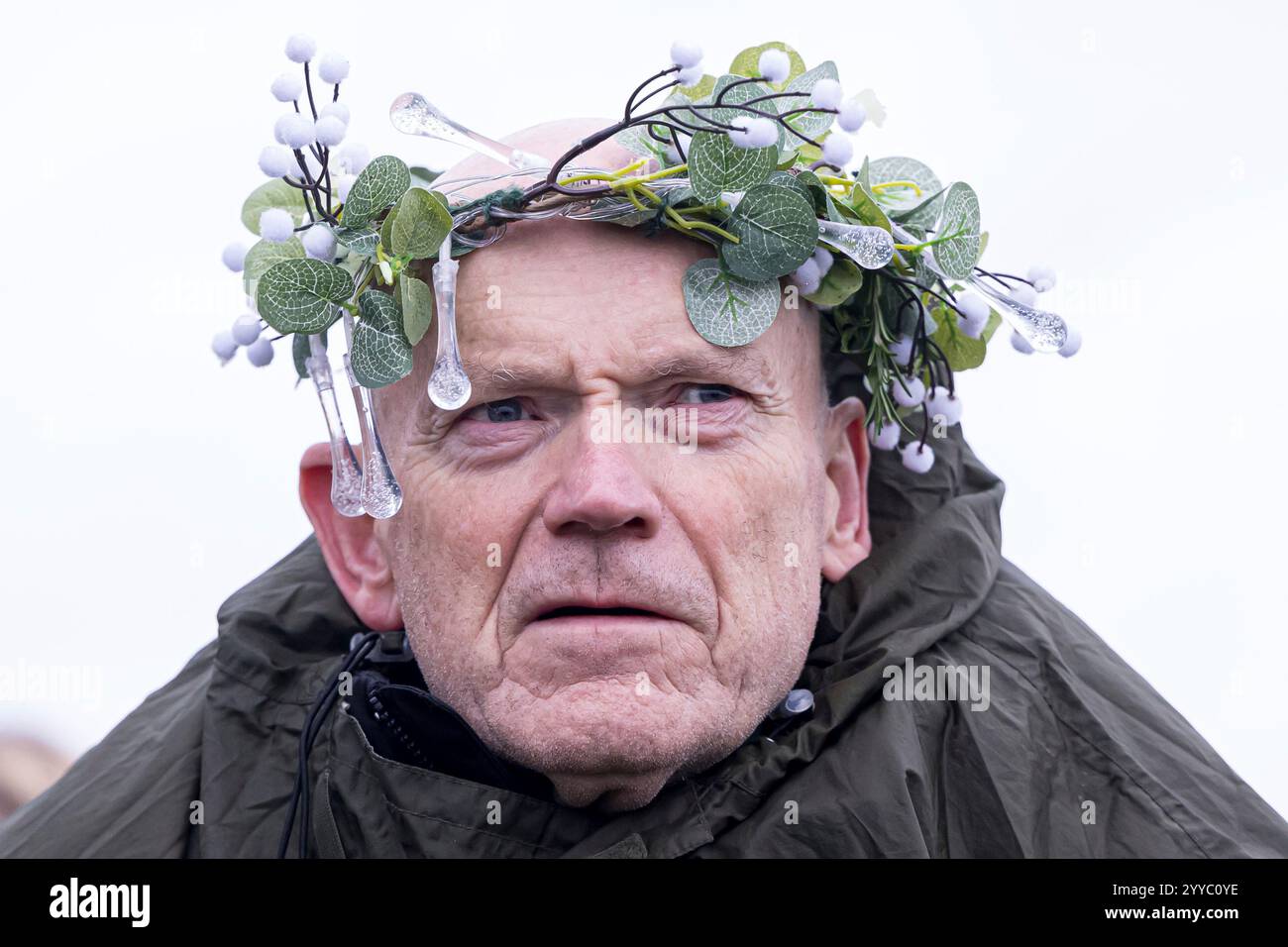 A ma wears a winter themed crown of of mistletoe and artificial lights