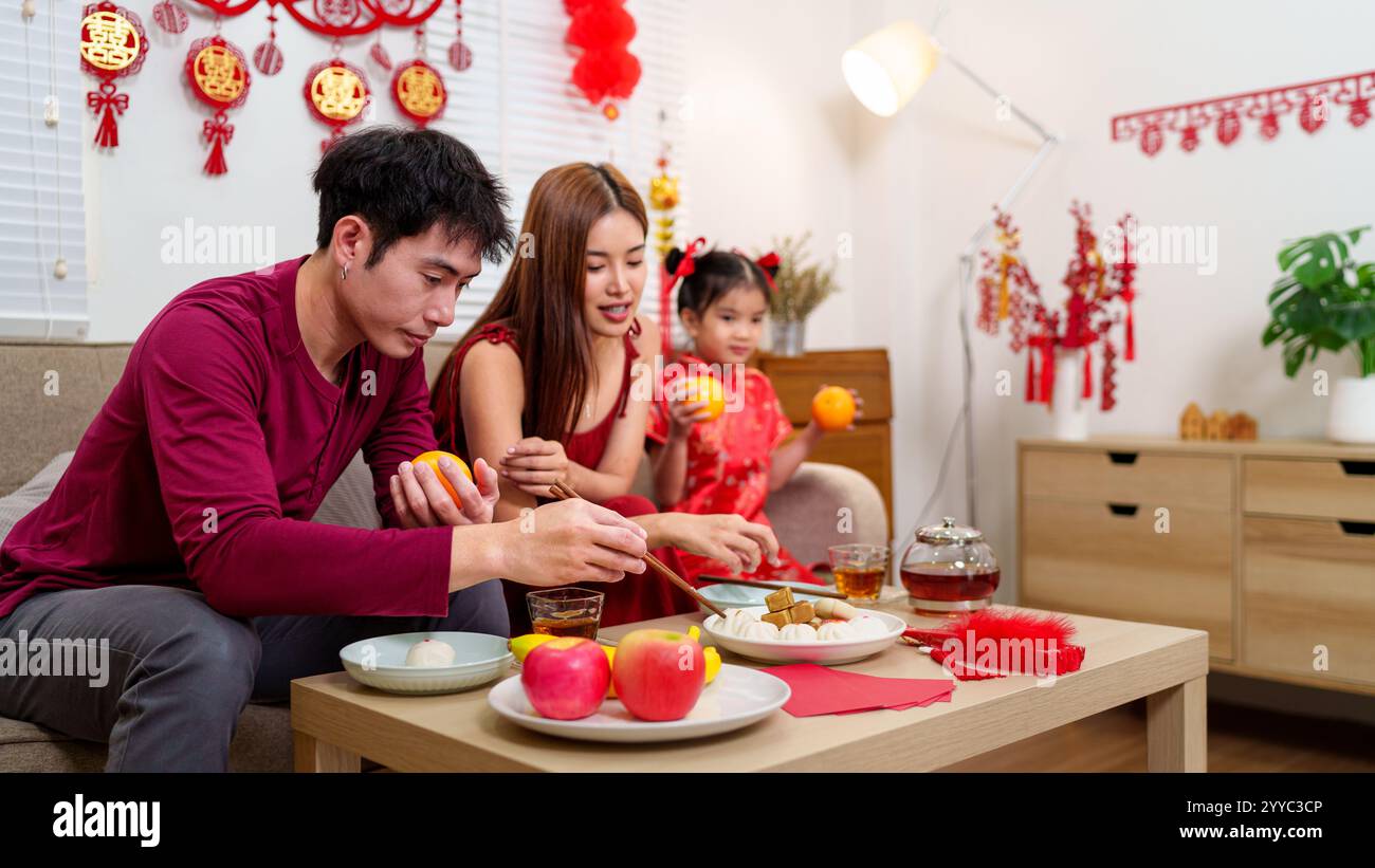 A Chinese family of three arranges a festive dining table to celebrate ...