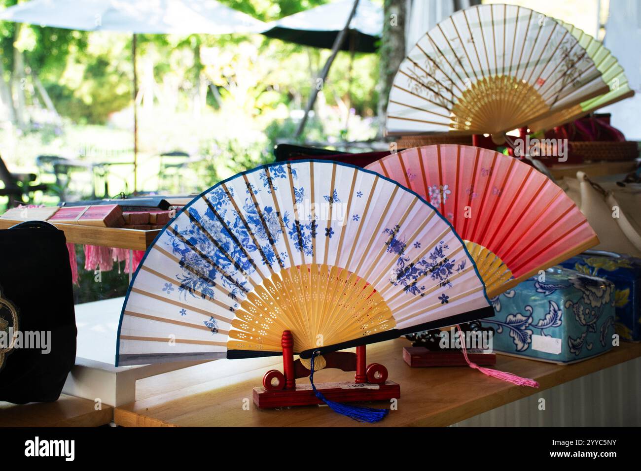 Vintage souvenirs handicraft silk hand fan or retro gift handmade paper fabric handheld folding fan with drawing painting antique style for thai peopl Stock Photo
