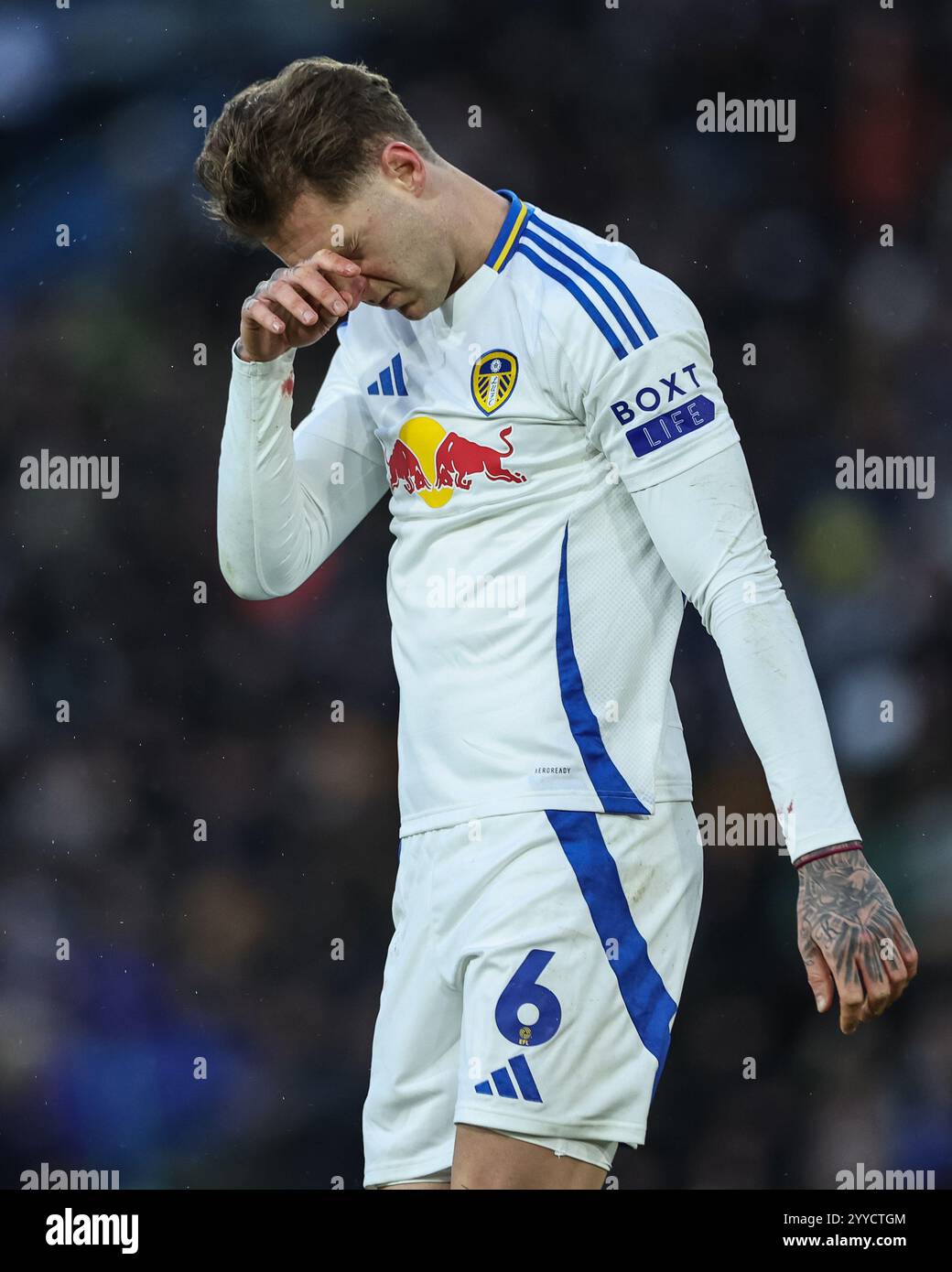 Joe Rodon of Leeds United rubs his head after receiving treatment ...