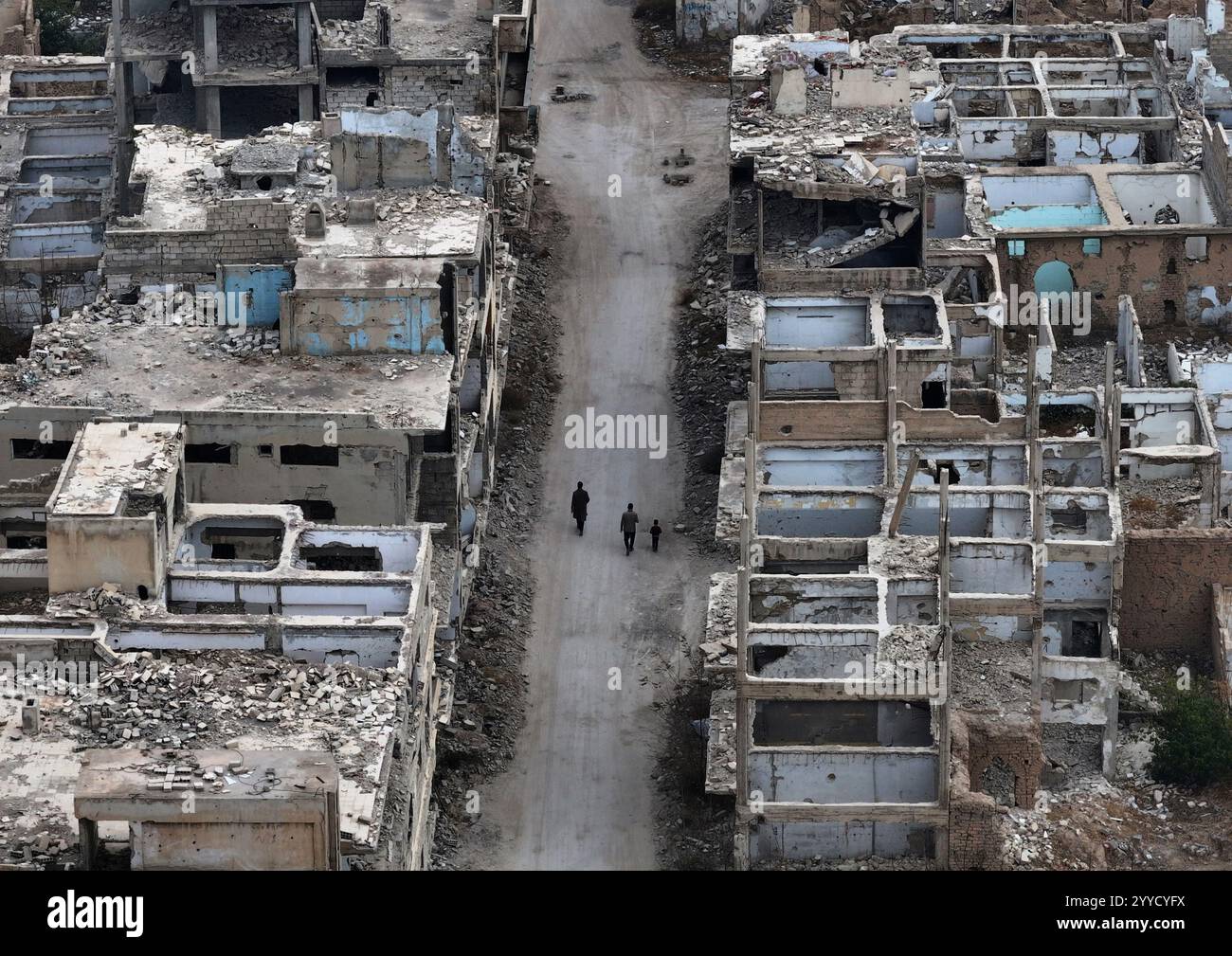 People walk between buildings that were destroyed during the civil war ...