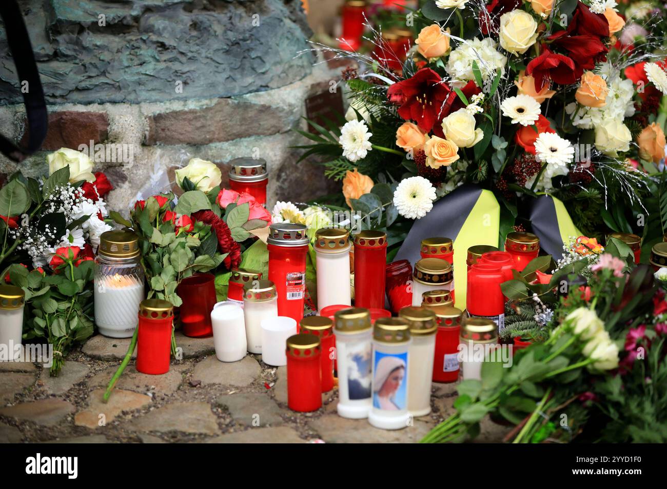 Menschen legen Blumen und Plüschtiere an der Johanniskirche nieder in