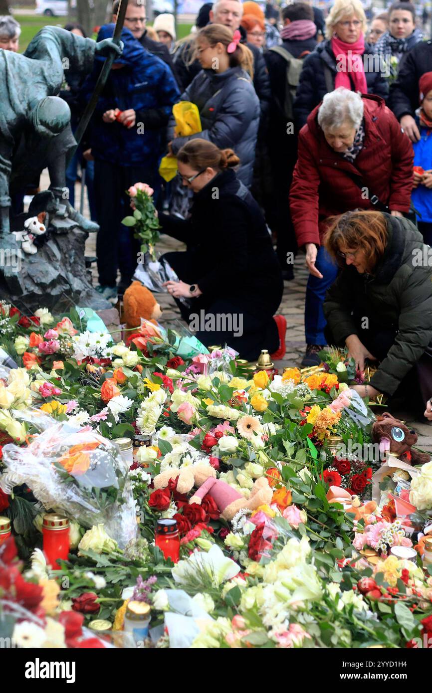 Menschen legen Blumen und Plüschtiere an der Johanniskirche nieder in