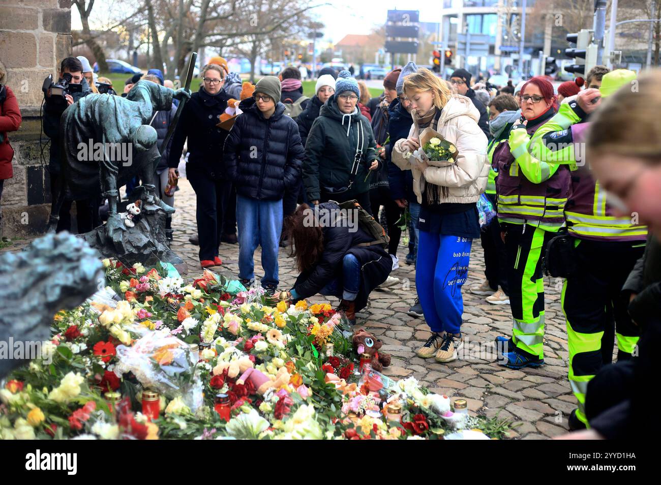 Menschen legen Blumen und Plüschtiere an der Johanniskirche nieder in