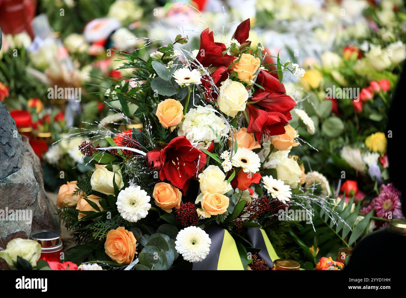 Menschen legen Blumen und Plüschtiere an der Johanniskirche nieder in