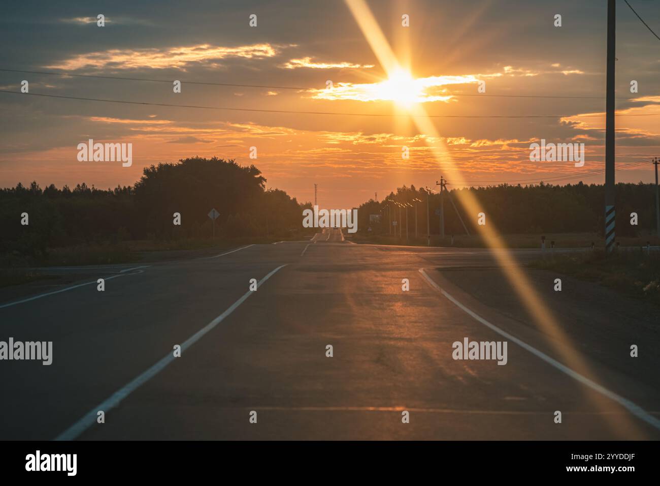 The asphalt road goes into the distance On the Sunset Stock Photo - Alamy