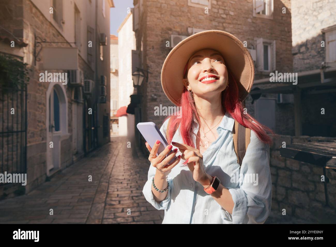 Tourist using mobile phone app for navigation while exploring budva old town, montenegro Stock Photo