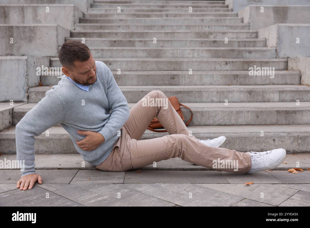 Injured man on stairs outdoors after fall. Dangerous accident Stock ...