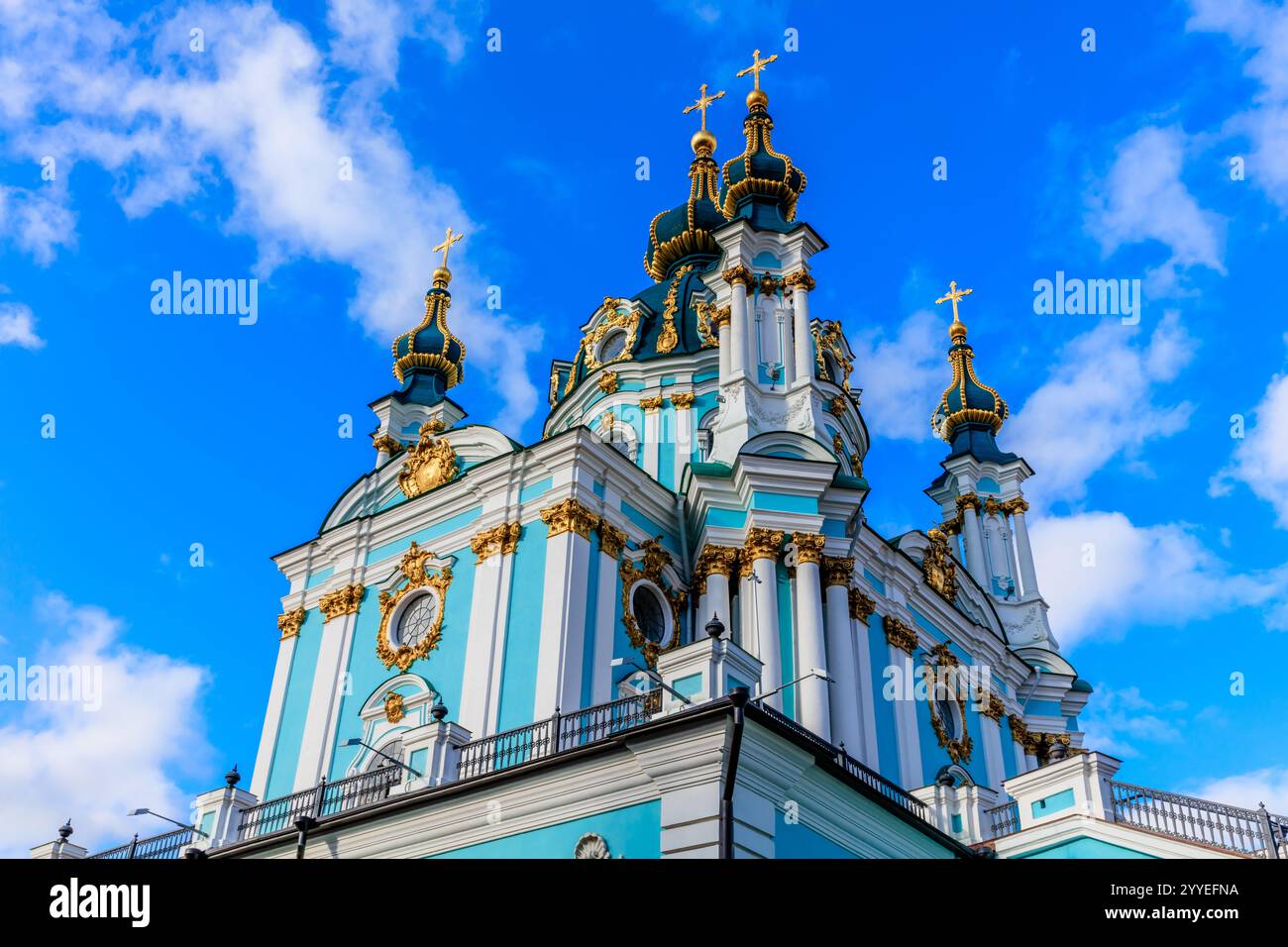 The blue and white church has a tall steeple and crosses on top. The ...