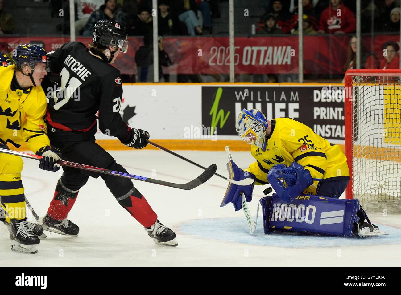 Sweden goaltender Melker Thelin makes a save on Canada forward Calum