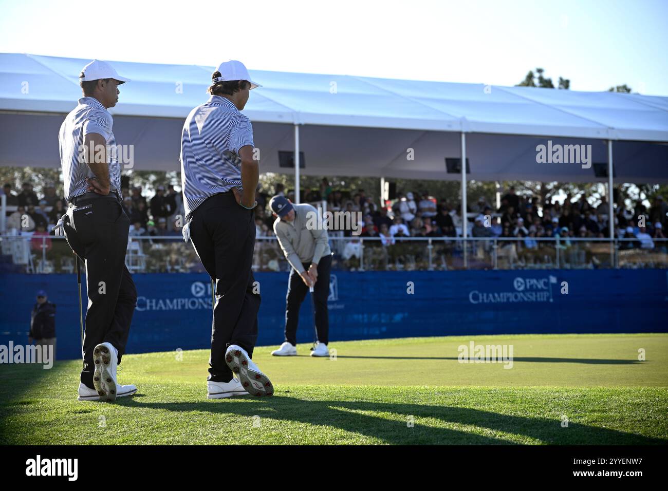 Tiger Woods, left, and his son Charlie Woods watch as Justin Leonard