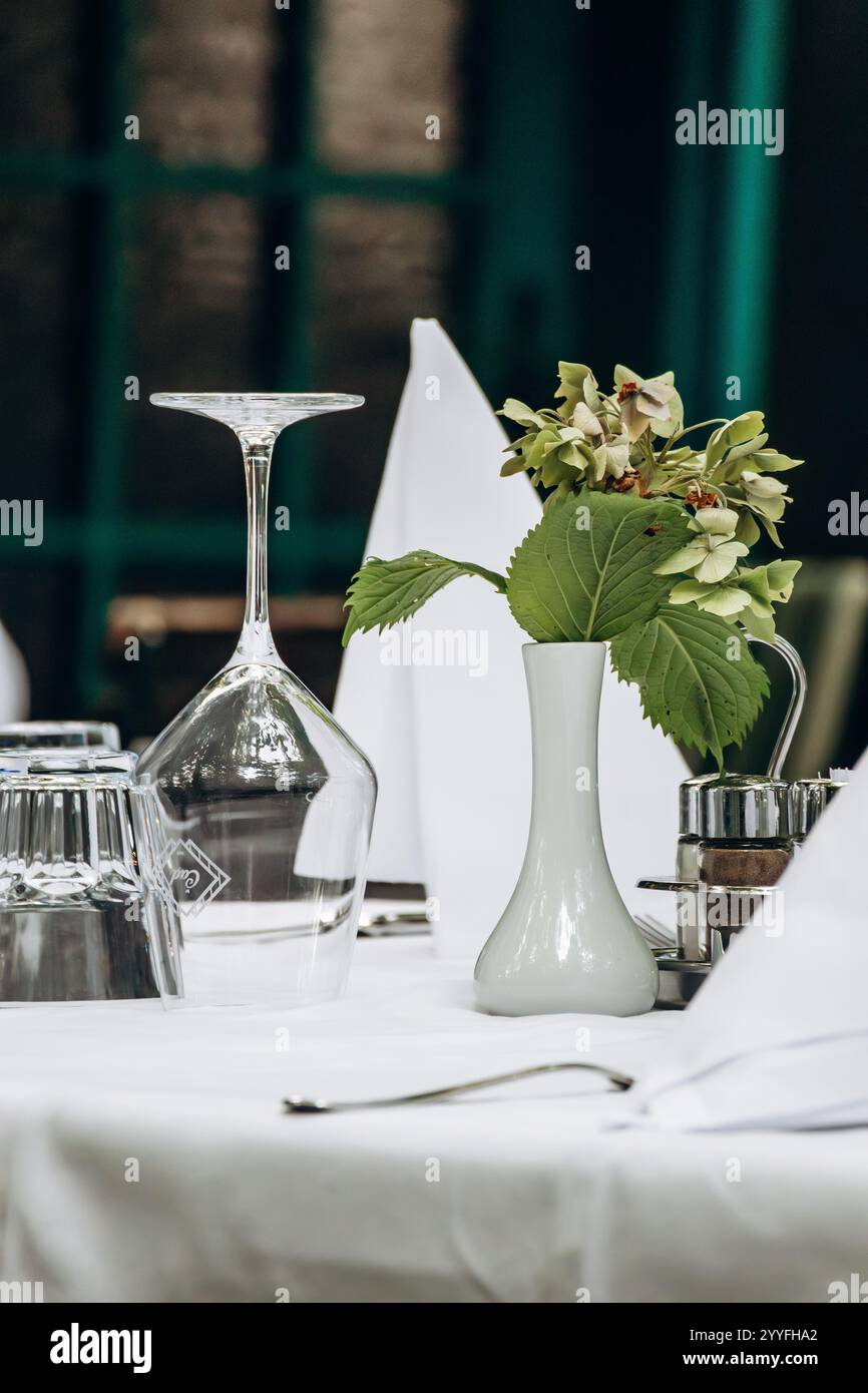 Elegantly Set Table with a White Tablecloth in a Restaurant Stock Photo