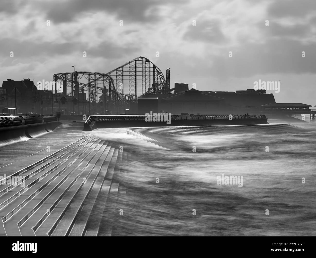 Blurred waves in motion crashing against the sea wall at Blackpool with the Pleasure Beach and Big One rollercoaster in the distance - Smartphone Captured Stock Image Blurred waves in motion crashing against the sea wall at Blackpool with the Pleasure Beach and Big One rollercoaster in the distance - Smartphone Captured Stock Image