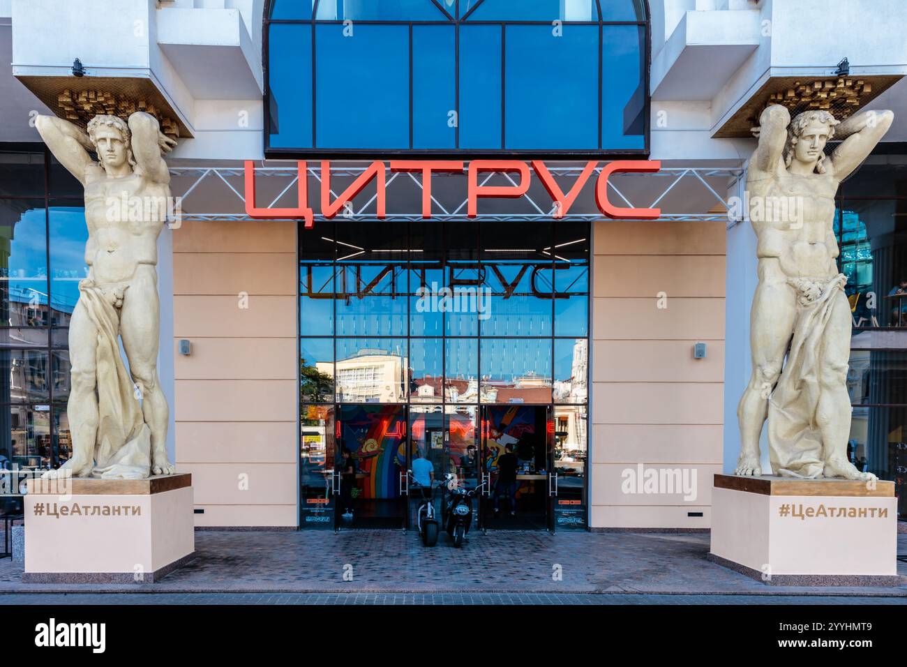 The building has two statues of men on either side of the entrance. The building is called Litviev Stock Photo