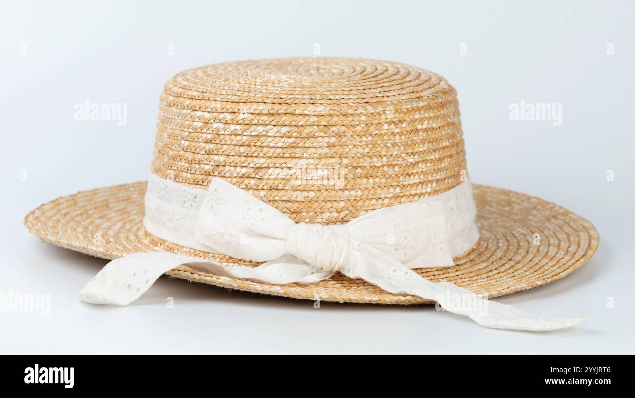 Brown straw hat with white bow isolated on studio background Stock Photo