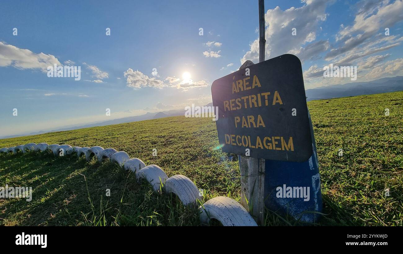 A stunning mountainous landscape under a clear blue sky with scattered fluffy clouds. Free flight take-off ramp. - Smartphone Captured Stock Image