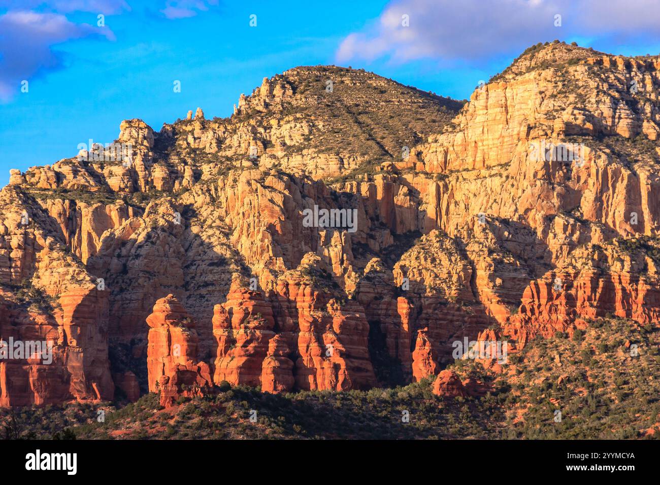 Red Rocks Mountians The mountains are covered in red rocks and the sky is blue. The sun is ...