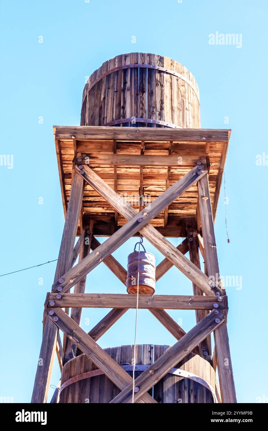 A wooden tower with a bell hanging from it. The tower is tall and has a ...