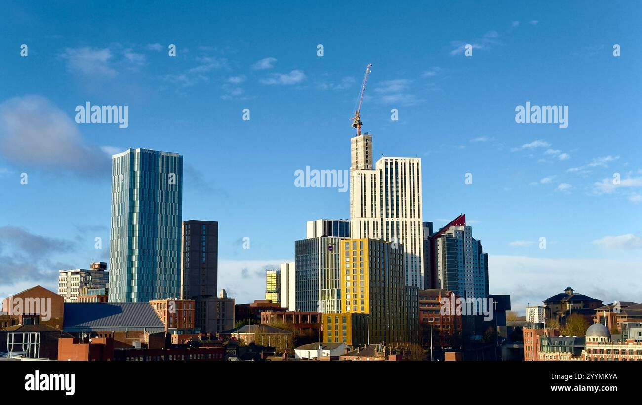 Aerial view of Leeds City Centre skyline with various tower buildings surrounding the town centre in West Yorkshire on a blue sky sunny day. Stock Photo