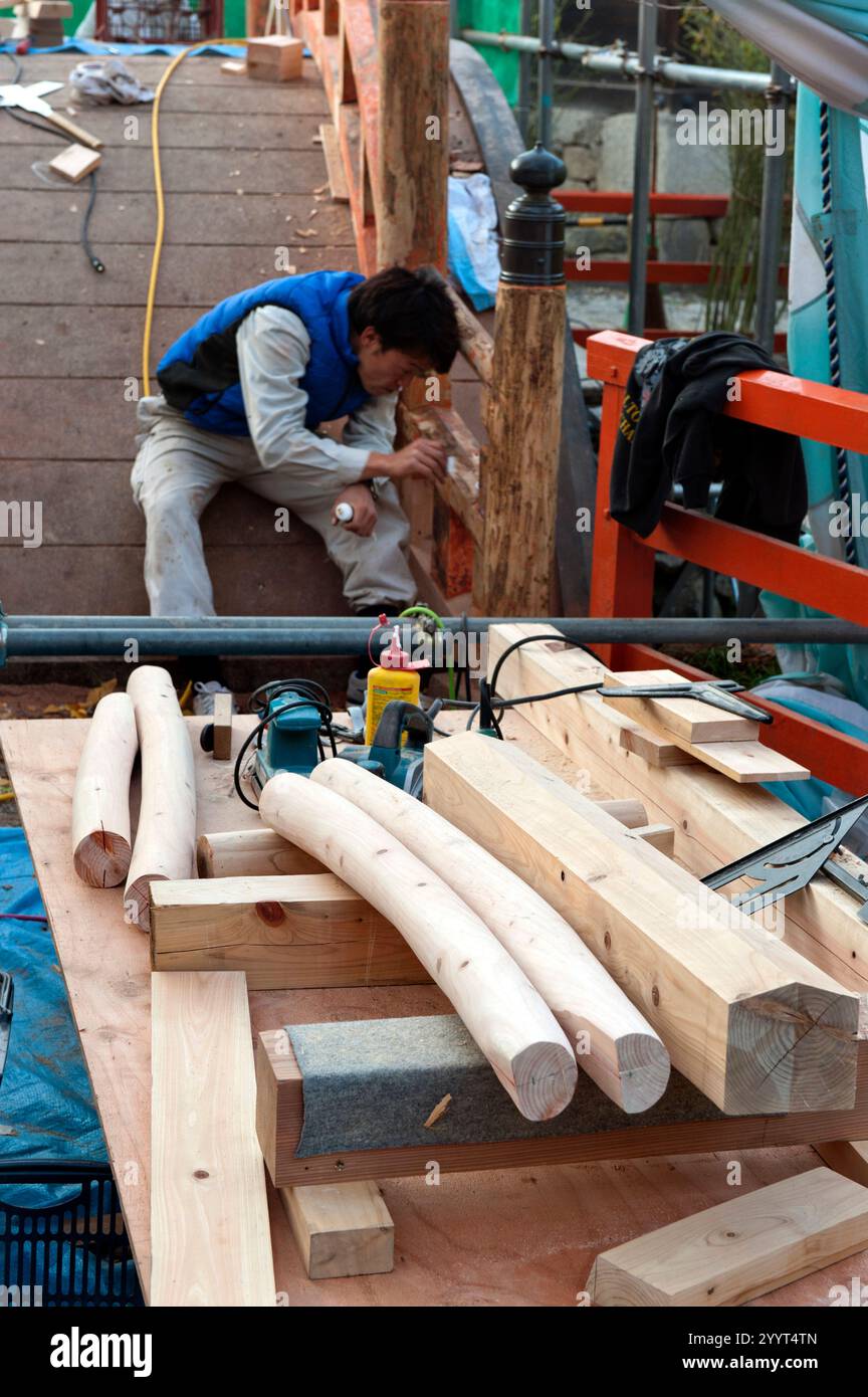 Miyadaiku are Japanese carpenters who specialize in building and maintaining shrines as seen here fixing a bridge at Kyoto's Shimogamo Jinja shrine. Stock Photo