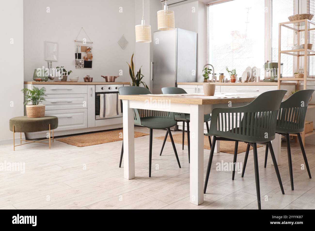 Interior of stylish kitchen with dining table, white counters and ...