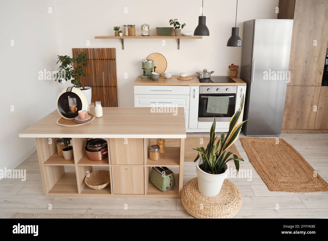 Interior of stylish kitchen with island table, houseplants and modern ...
