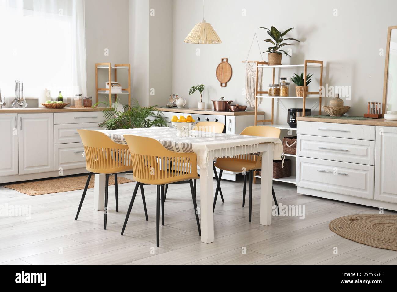 Interior of light kitchen with counters, shelf units and dining table ...